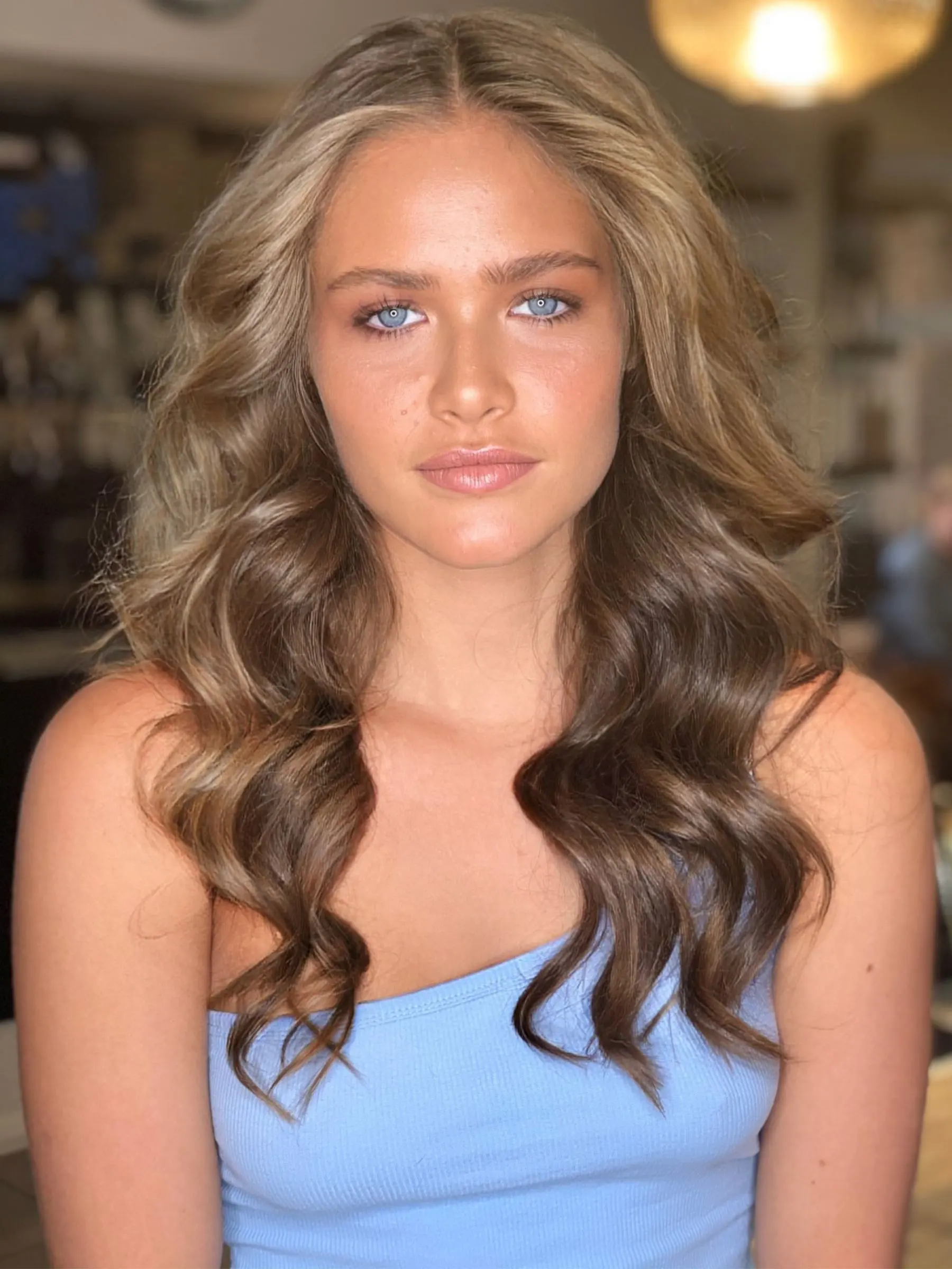 Long brunette waves lifted with soft blonde through the lengths, coloured with NATULIQUE at Erin Morgan Hair Subiaco